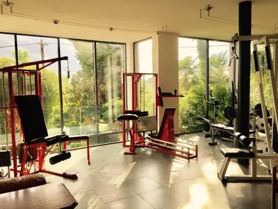 a large room with a gym with large windows at Villa Verdi Apartments in Merano