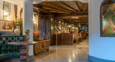 a dining room with a table and a couch at Hotel Ai Pini in Vigo di Fassa