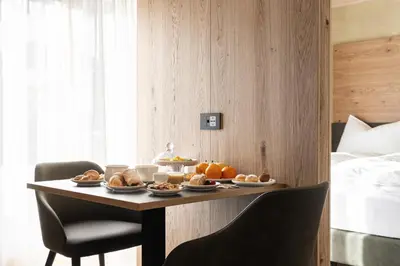 a table with food on it in a hotel room at Garnì La Violetta in Soraga