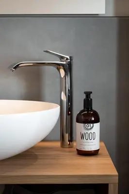 a bottle of wood soap sitting next to a sink at Garnì La Violetta in Soraga