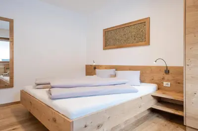 a bed with two pillows on it in a room at Vettererhof in Lana