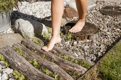 a person standing on a log in a rock garden at Vettererhof in Lana