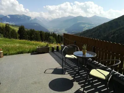 a table and chairs on a patio with a view of mountains at Bigraberhof in Valdaora