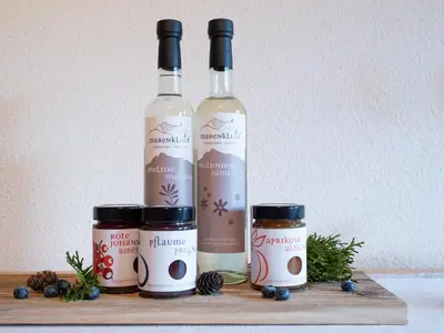 a group of three bottles of wine on a wooden shelf at Marenklhof in Tesido
