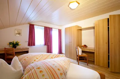 a hotel room with a bed and a desk and a bedroom at Marenklhof in Tesido