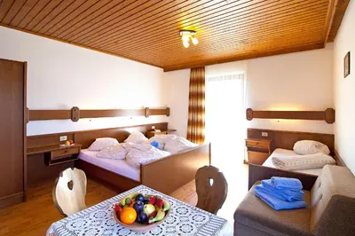 a room with two beds and a table with a bowl of fruit at Marenklhof in Tesido