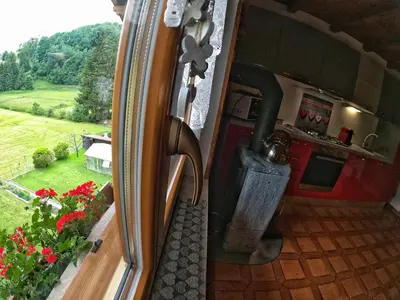 a view of a kitchen with a stove and a window at Casa Aurora -Altopiano di Pinè in Bedollo