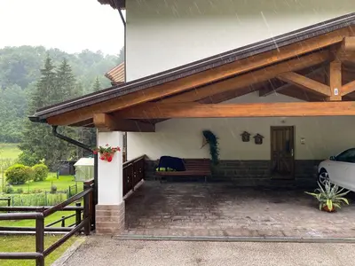 a porch of a house with a wooden roof at Casa Aurora -Altopiano di Pinè in Bedollo