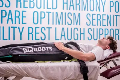 a man laying on a bed with a suitcase at Sporthotel Zoll in Vipiteno