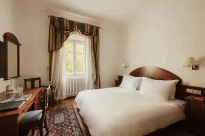 a bedroom with a bed and a desk and a window at Corso am Graben in Brunico
