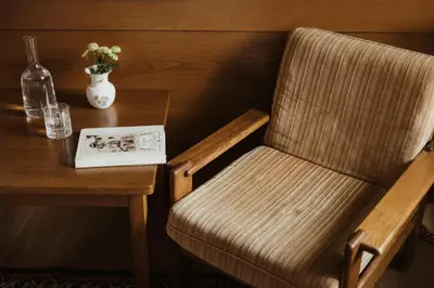 a book sitting on a table next to a wooden chair at Corso am Graben in Brunico