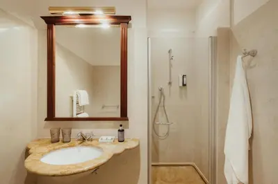a bathroom with a sink and a shower with a mirror at Corso am Graben in Brunico