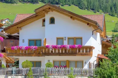 a house with flowers on the balcony at Villa Martha ex Garnì Oskar in Corvara in Badia