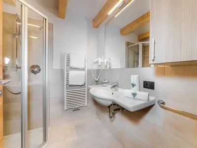 a white bathroom with a sink and a shower at Residence Brunello in Ortisei