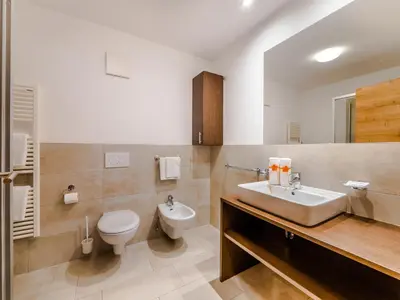 a bathroom with a white toilet and a sink at Residence Brunello in Ortisei