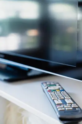 a remote control sitting on a table in front of a television at Villa Floris in Bressanone