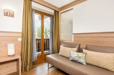 a living room with a couch and a window at Hotel Pontechiesa in Cortina dʼAmpezzo