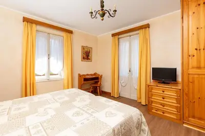 a bedroom with a bed and a flat screen tv at Hotel Pontechiesa in Cortina dʼAmpezzo
