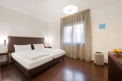 a bedroom with a large bed and a window at Hotel Asterix in Bolzano