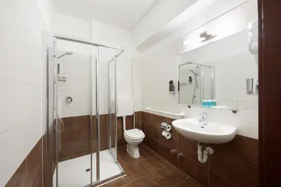 a bathroom with a toilet and a sink and a shower at Hotel Asterix in Bolzano