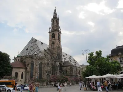a large cathedral with a clock tower in a city at Hotel Asterix in Bolzano