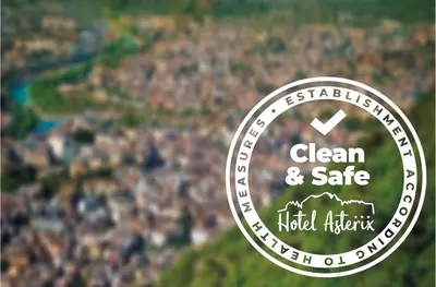 a sign that reads clean and safe with a city in the background at Hotel Asterix in Bolzano
