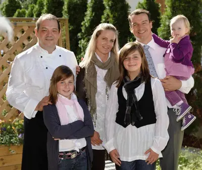 a family is posing for a picture together at Hotel Millanderhof in Bressanone