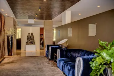 a living room with blue couches and a statue at Art & Design Hotel Napura in Bolzano