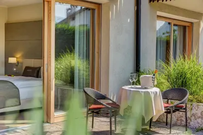 a patio with a table and chairs and a bed at Art & Design Hotel Napura in Bolzano