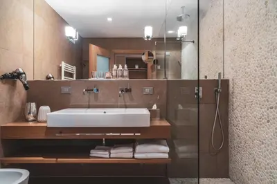 a bathroom with a sink and a glass shower at Art & Design Hotel Napura in Bolzano