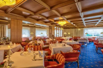 a dining room with white tables and chairs at Diamant Spa Resort in Santa Cristina in Val Gardena