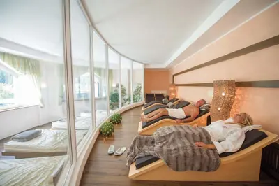 a group of people laying on beds in a room at Diamant Spa Resort in Santa Cristina in Val Gardena