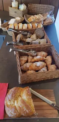 a table topped with baskets of bread and baskets of pastries at gasthof pension rössl in Nova Ponente