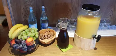 a table with a bottle of juice and a bowl of fruit at gasthof pension rössl in Nova Ponente