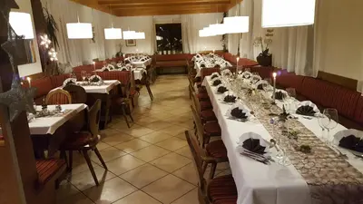 a row of tables in a restaurant with white table settings at gasthof pension rössl in Nova Ponente