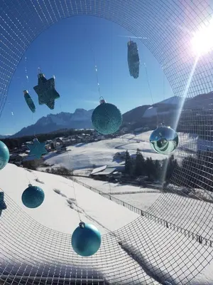 a group of christmas ornaments hanging from a net at gasthof pension rössl in Nova Ponente