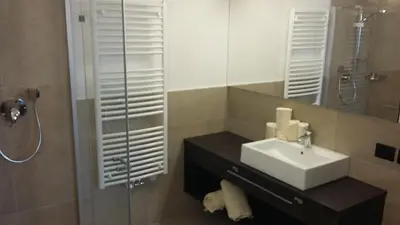 a bathroom with a sink and a shower with a mirror at App. Villa Fraina in San Cassiano