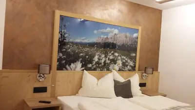 a bedroom with a large painting above a bed at App. Villa Fraina in San Cassiano
