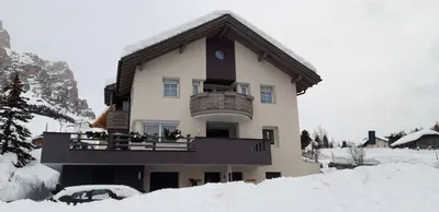 a building with a balcony in the snow at App. Villa Fraina in San Cassiano