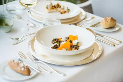 a table with plates and a bowl of food on it at Hotel Resmairhof in Schenna
