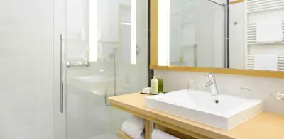a bathroom with a sink and a shower at Hotel Resmairhof in Schenna