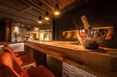 a kitchen with a bar with a fireplace at Hotel Christiania in La Villa