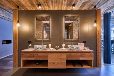 a bathroom with two sinks and two mirrors at Hotel Christiania in La Villa