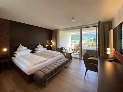 a bedroom with a large bed and a balcony at Dominik Alpine City Wellness Hotel - Adults only in Bressanone