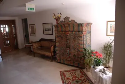 a living room with a couch and a large rug at Hotel Mondschein in Vipiteno