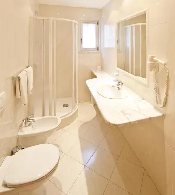 a bathroom with a toilet and a sink and a shower at Hotel Mondschein in Vipiteno