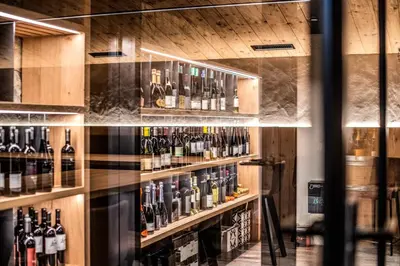 a room filled with lots of bottles of wine at Hotel Mondschein in Vipiteno