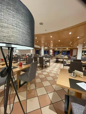 a restaurant with tables and chairs and a large lamp at Hotel Larch in Campo di Trens