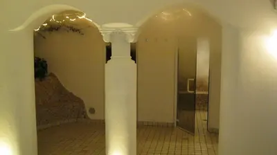 a hallway with a pillar in a room with a mirror at Hotel Larch in Campo di Trens