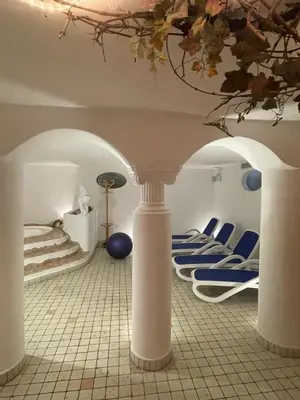 a room with blue and white chairs and a ceiling at Hotel Larch in Campo di Trens